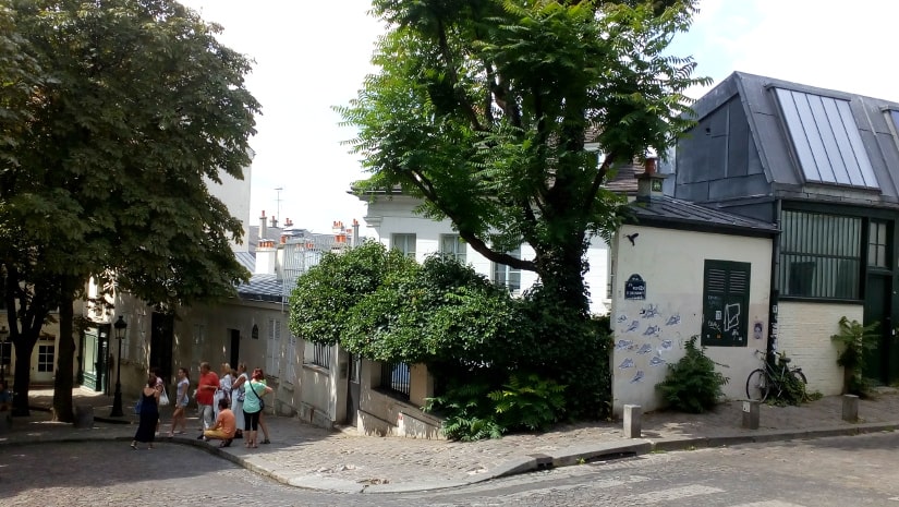 A general view of the Bateau Lavoir artists studios and workshops. The view is from Rue Ravignan looking west. Some tourists and visitors are visible.