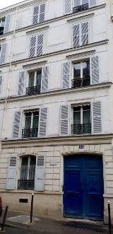 A view of a typical 4 storey white Parisian apartment block. The windows have shutters. Theo and Vincent van Gogh lived here in 1886-1888.
