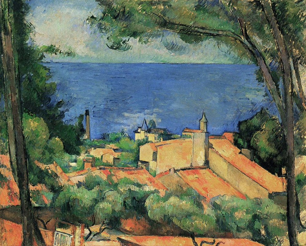 One of Paul Cézanne’s many studies of the southern French town of L’Estaque. Some blocky ochre buildings with red roofs are simply evoked. The scene is framed by two large trees. In the distance a blue and turquoise sea with beyond that a vague green and yellow area which suggests adjacent land.