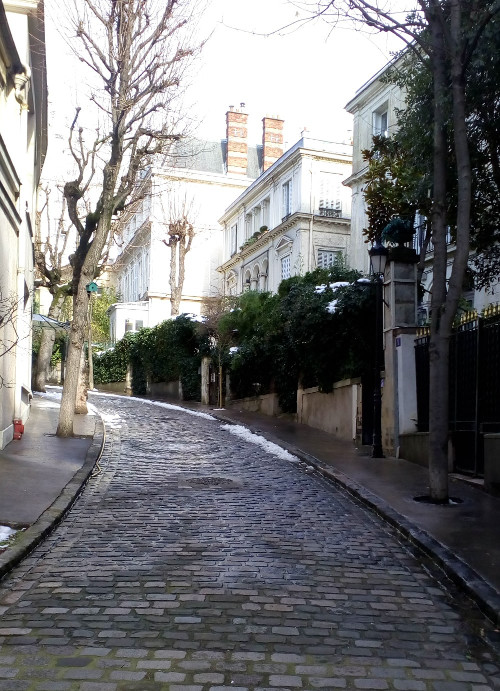 Looking up the curving cobbled Avenue Frochot in Montmartre. The avenue is tree lined and the large houses surrounded by gardens. Toulouse-Lautrec had a studio and apartment here in the late 1890s.