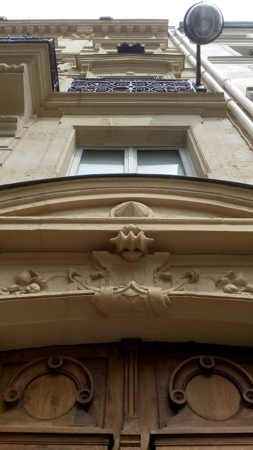 A view of the entrance of 30 Rue Pierre Fontaine in Montmartre. Toulouse-Lautrec lived here in the mid 1890s. The image shows the view looking up the stone facade of the four storey building. Wrought iron balconies are visible and the number 30 appears above the door.