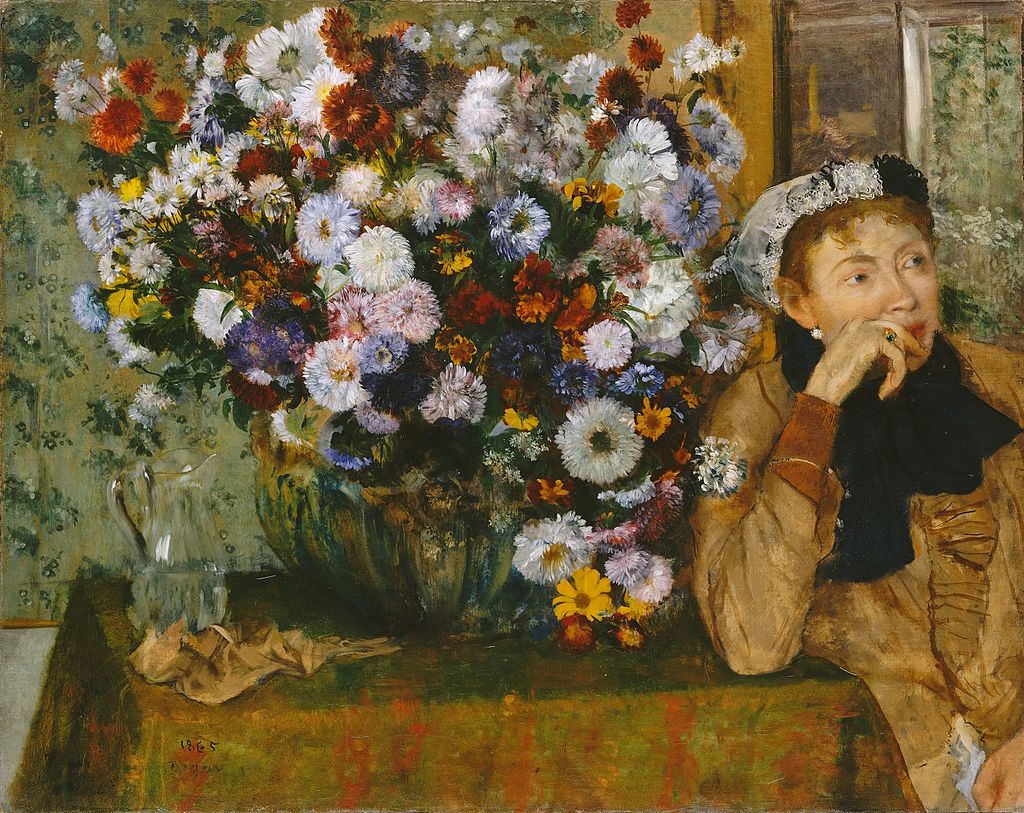 A woman, her head propped up by her hand, looks absent mindedly out of the frame beyond the viewer. She is sitting by a small table on which is placed a huge display of flowers in a vase. The flowers are complemented by floral wall paper in the background.